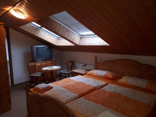ein Schlafzimmer mit einem großen Bett und einem Dachfenster in der Unterkunft Meschkes Gasthaus Pension in Hohnstein