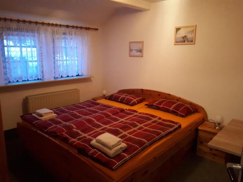 Schlafzimmer mit einem großen Bett mit roter Bettwäsche und einem Fenster in der Unterkunft Meschkes Gasthaus Pension in Hohnstein