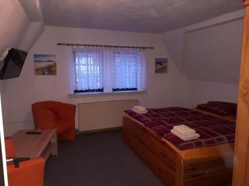 a bedroom with a bed and a desk and a window at Meschkes Gasthaus Pension in Hohnstein