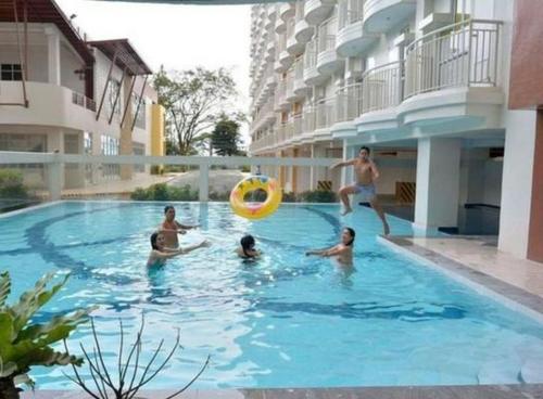 a group of people playing with a frisbee in a swimming pool at HappyNest Couple room DF in Tagaytay