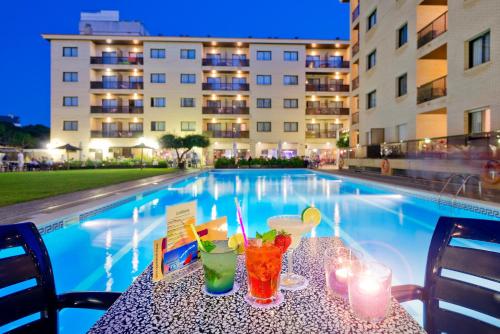 a table with drinks on it next to a swimming pool at Olimar II in Cambrils