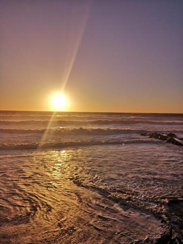a sunset on the beach with the ocean at Agriturismo Costa di Campo in Vernazza