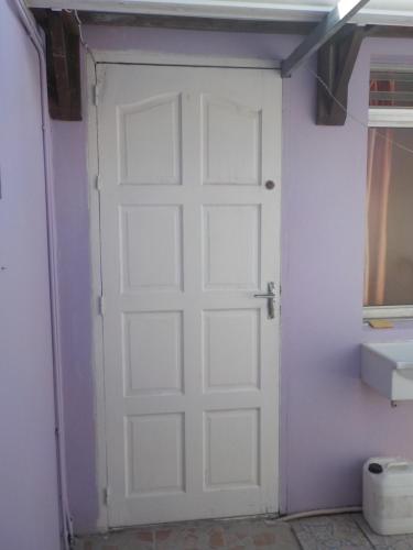 Una puerta blanca en una habitación con lavabo en Petit Studio bateliere en Schœlcher