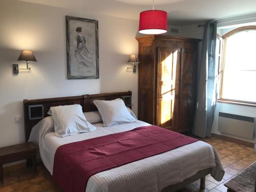 Un dormitorio con una cama con una manta roja y una ventana. en La Clue/ le Jas du Ventoux, en Plaisians