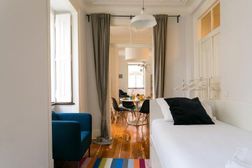 リスボンにあるALTIDO Splendid 2BR flat in Bairro Alto, nearby Luís de Camões Squareのベッドルーム1室(ベッド1台、青い椅子、テーブル付)