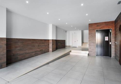 a hallway with a black door and wooden walls at Sunny Sea in La Mata