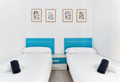 two beds in a room with blue and white at Sunny Sea in La Mata