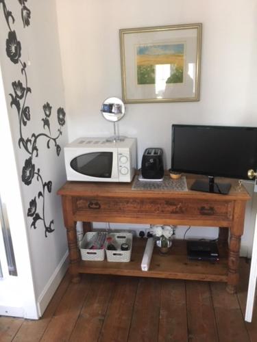 una mesa con microondas y una TV en ella en House on the Corner B&B en Didcot