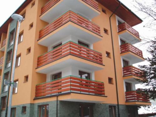 a building with red balconies on the side of it at Apartmán Pálenica II in Tatranska Strba