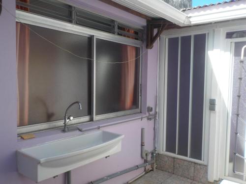 uma casa de banho com um lavatório e uma janela em Petit Studio bateliere em Schœlcher