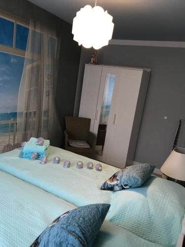 a bedroom with a large bed with a window at Apartament Perła - Słoneczne Tarasy in Dziwnówek
