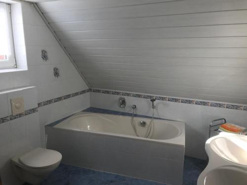a bathroom with a tub and a toilet and a sink at Urlaub auf dem Bauernhof Zeller in Wolframs-Eschenbach