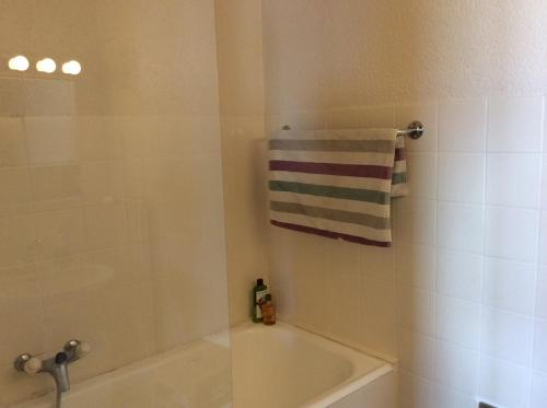 a bathroom with a tub and a shower with a towel at Immeuble Belvédère in Les Collons