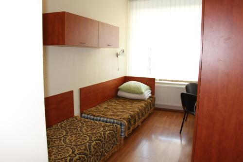 a room with a bed and a chair and a window at Ignalinos sporto ir pramogų centras in Ignalina