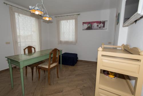 a dining room with a green table and chairs at Matilde in Isola delle Femmine