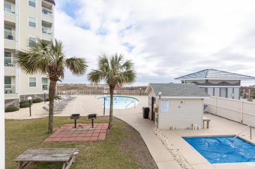 un patio con una mesa de picnic y una piscina en A Place at the Beach by Capital Vacations en Myrtle Beach