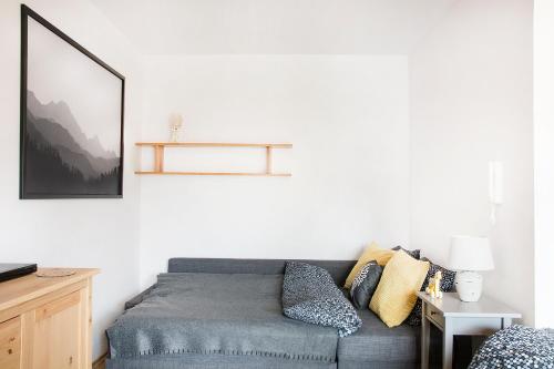 a living room with a couch and a picture on the wall at Apartament Malowany Konik in Zakopane