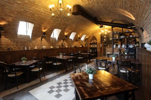 a restaurant with tables and chairs and a chandelier at Arhiv Boutique House in Novi Sad