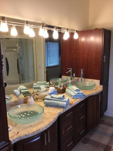 a bathroom with two sinks and a large mirror at A Slice of Paradise in Jensen Beach