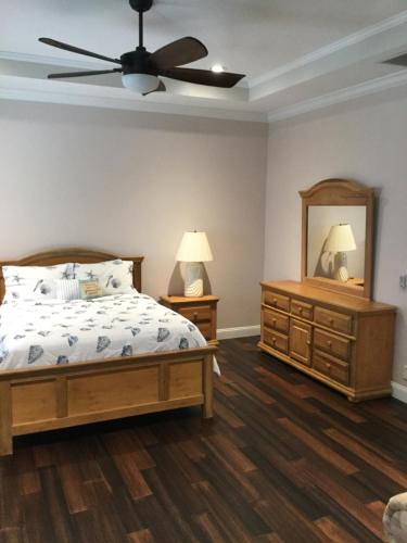 a bedroom with a bed and a ceiling fan at A Slice of Paradise in Jensen Beach