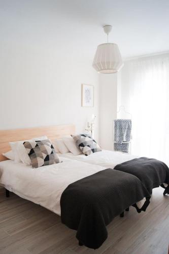 a white bedroom with a large bed in a room at Ekilore - Basquenjoy in Hondarribia
