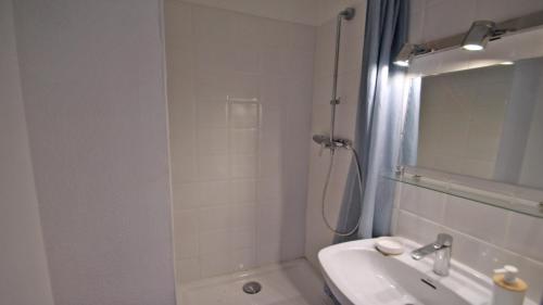 une salle de bain blanche avec une douche et un lavabo dans l'établissement Boucanniers, à Sainte-Maxime