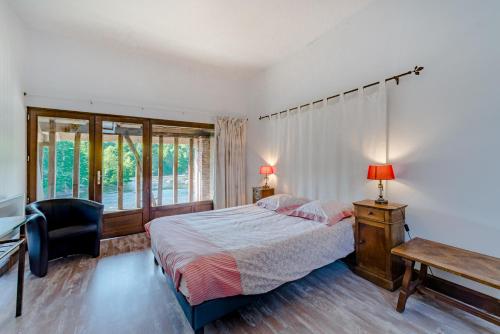 um quarto com uma cama, uma secretária e uma janela em Moulin du Daumail em Saint-Priest-sous-Aixe