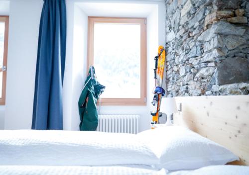 a bedroom with a bed and a window and skis at Bed&Bike Tremola San Gottardo in Airolo