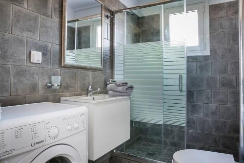 uma casa de banho com um lavatório e uma máquina de lavar roupa em Julia's Superior Suites em Kástron