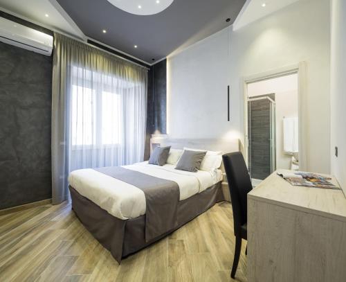 una camera con letto, tavolo e finestra di Hotel Bella Napoli a Napoli