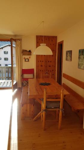 a dining room with a wooden table and a lamp at Chesa Dal Gial - Celerina in Celerina