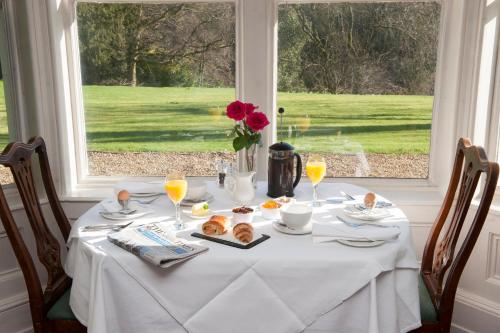 a table with a white table cloth and a window at Langrish House in Petersfield