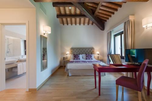 a bedroom with a bed and a desk with a computer at Borgo La Chiaracia Resort & SPA in Castel Giorgio