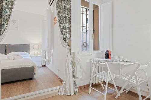 a white bedroom with a bed and a table and chairs at Sognando Bologna Flat in Bologna