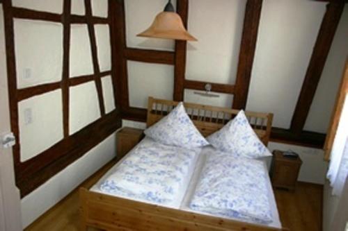 a bedroom with a wooden bed with pillows on it at Romantisches Torhaus in Sommerhausen
