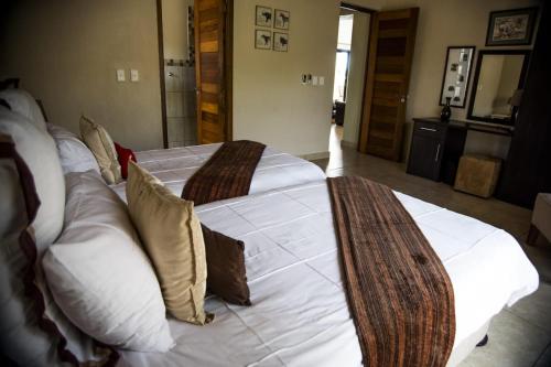 a bedroom with two beds with white sheets and pillows at Crocodile Bend in Mpakeni