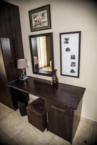 a desk with a mirror and a lamp in a room at Crocodile Bend in Mpakeni