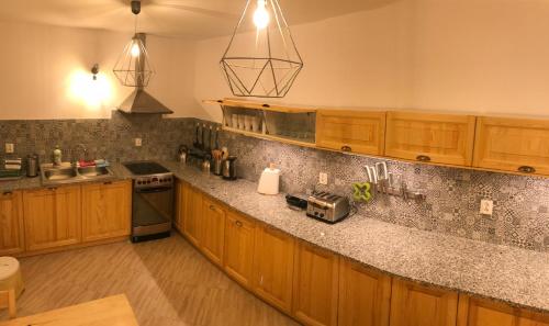 een keuken met houten kasten en granieten aanrechtbladen bij Lawendowy Zakątek in Kołczewo