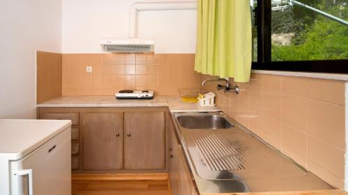 a small kitchen with a sink and a window at Pharos Rooms in Ilia