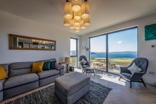 a living room with a couch and chairs and a large window at Oran Na Mara, Waternish in Hallin