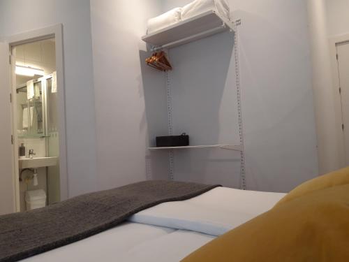 a small bedroom with a bed and a mirror at Pensión La Perla in Donostia-San Sebastián