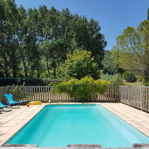 - une piscine dans une cour avec 2 chaises dans l'établissement Gîte Aux Tournesols, à Malaucène