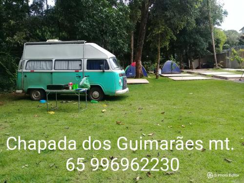 a green and white van parked in a field at CAMPING RECANTO DOS PÁSSAROS in Chapada dos Guimarães