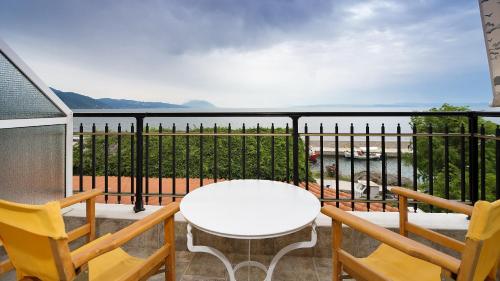 a balcony with a white table and two chairs at Pharos Rooms in Ilia