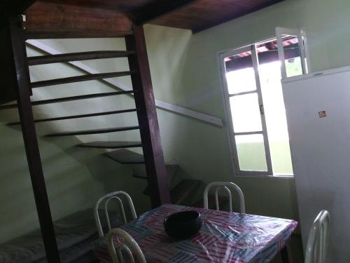 una sala da pranzo con tavolo e scala a chiocciola di Apartamentos vista mar Praia de Jacaraípe a Serra