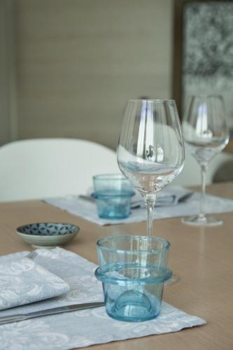 a table with three wine glasses and bowls on it at Ristolocanda Grani Di Pepe in Flaibano