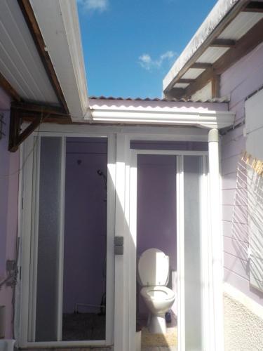 a toilet sitting on the outside of a house at Petit Studio bateliere in Schœlcher