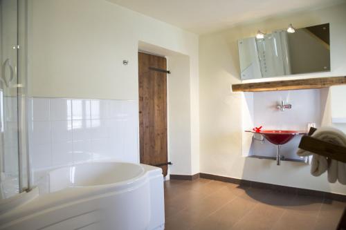 a bathroom with a tub and a toilet and a sink at Ristolocanda Grani Di Pepe in Flaibano