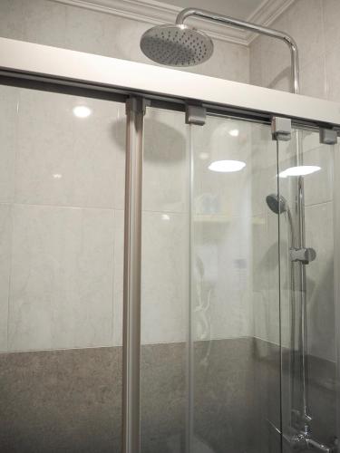 a shower with a glass door in a bathroom at Pensión Urkia in Donostia-San Sebastián