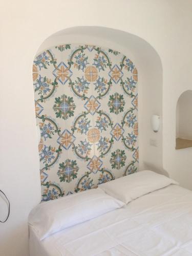 a bed in a room with a patterned wall at Hotel 4 Stagioni in Capri